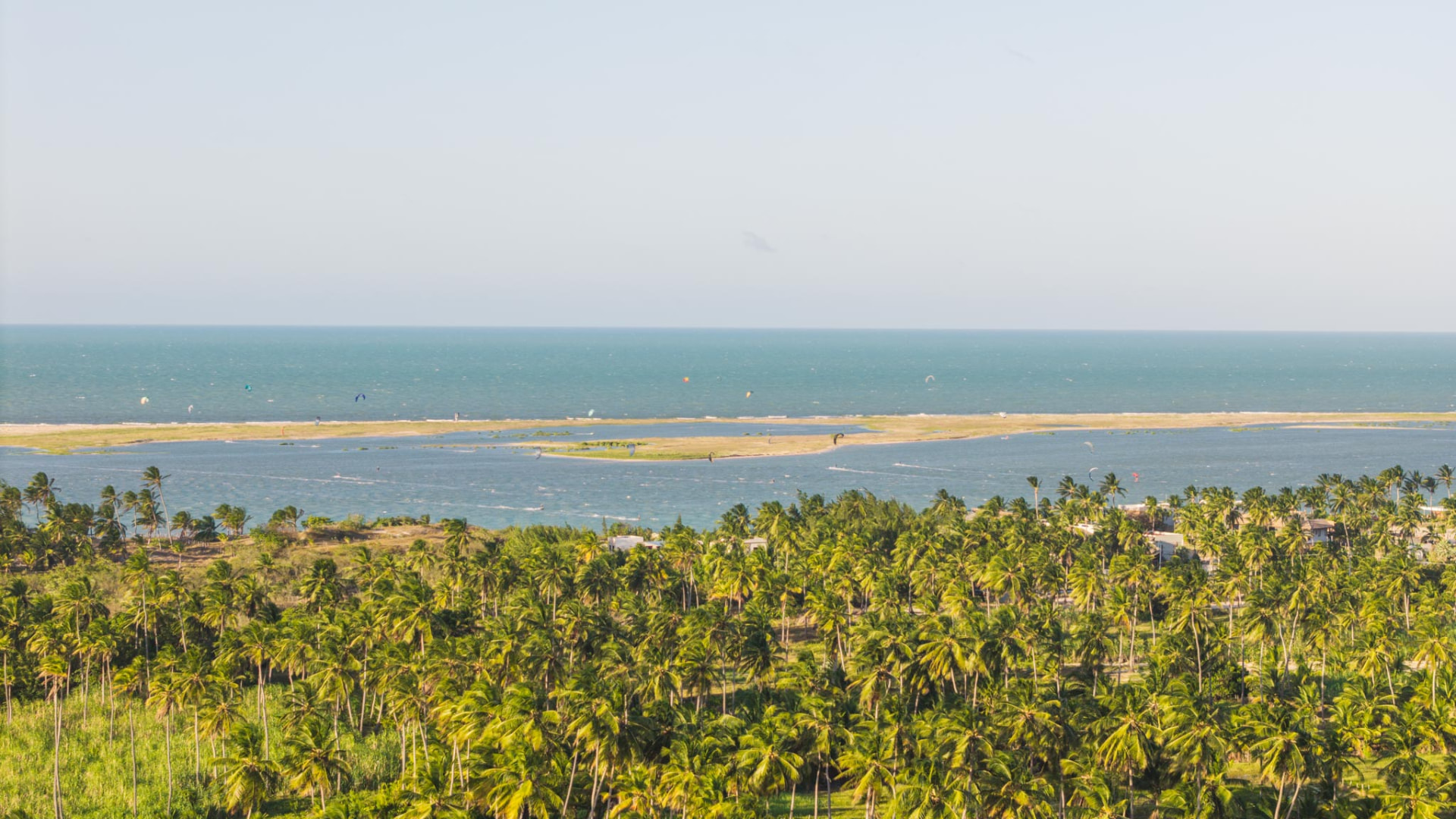 Vista aérea dos coqueirais, da lagoa e do mar na Ilha do Guajiru